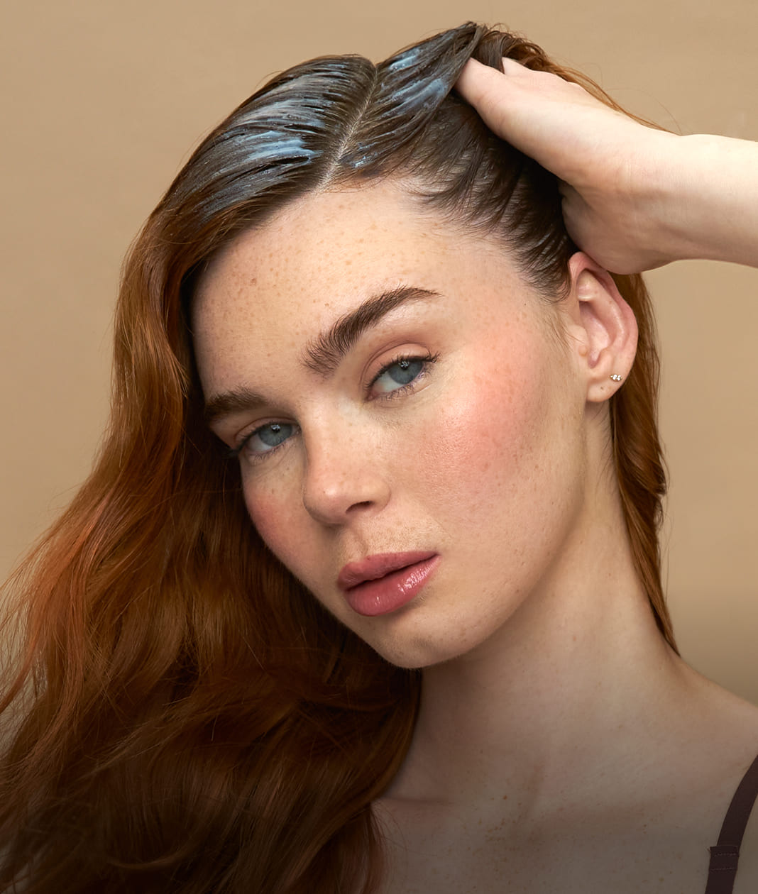 Woman with styled hair against a beige background