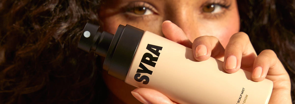 Close up of model holding the essence scalp mist