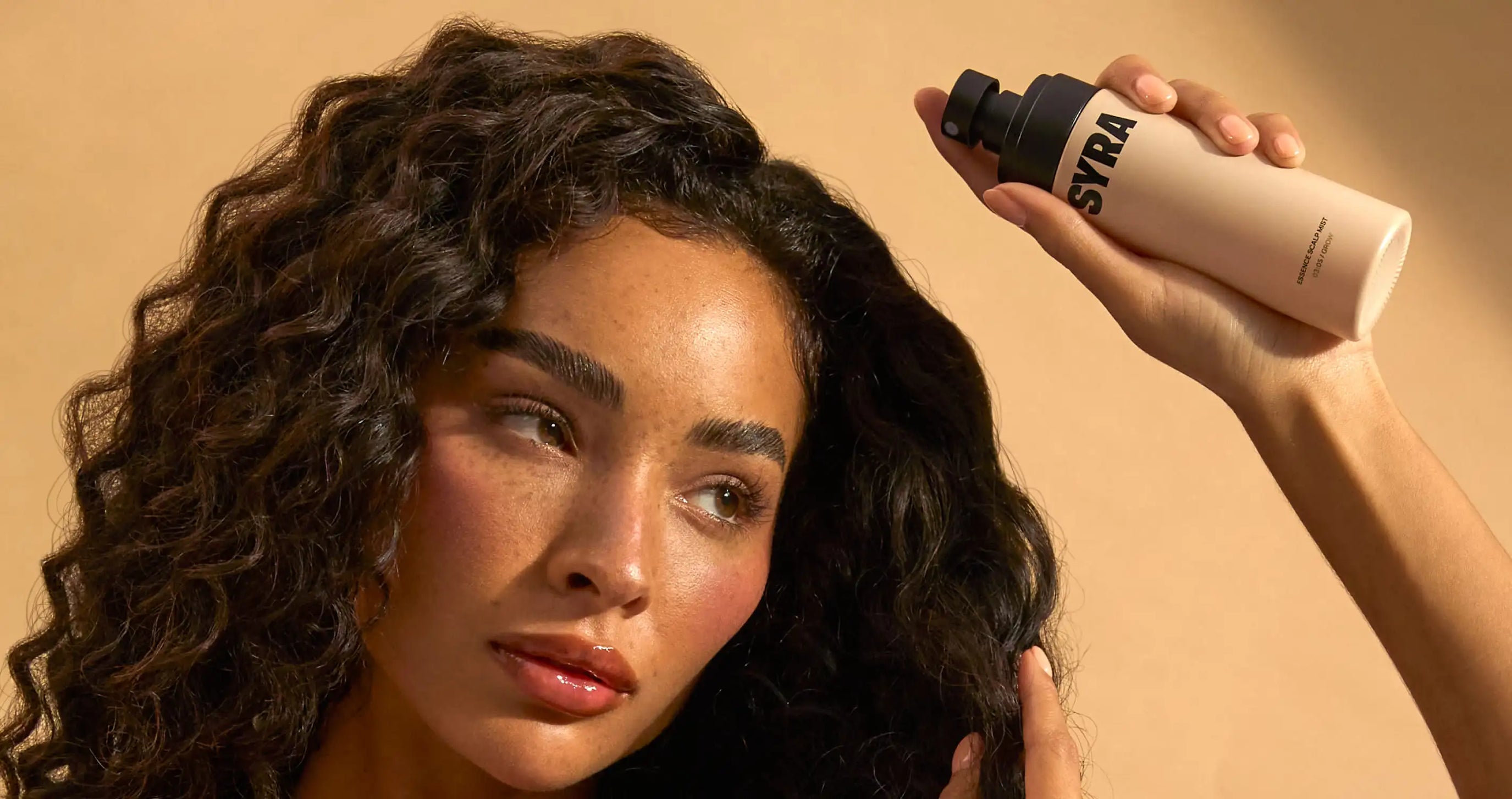 Woman holding Syra essence hair growth spray