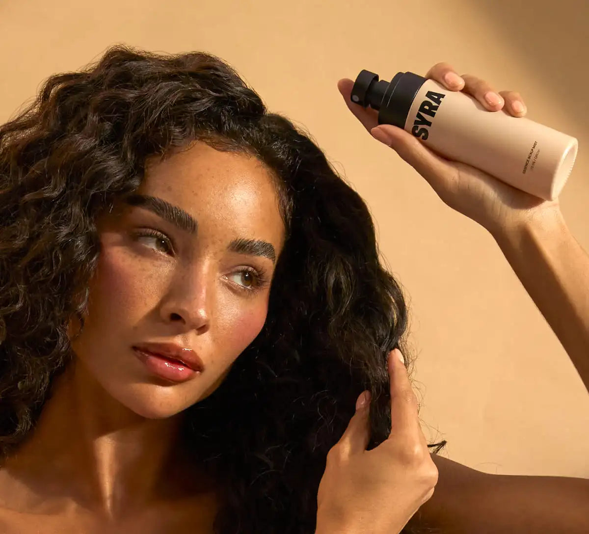 Woman holding Syra essence hair growth spray