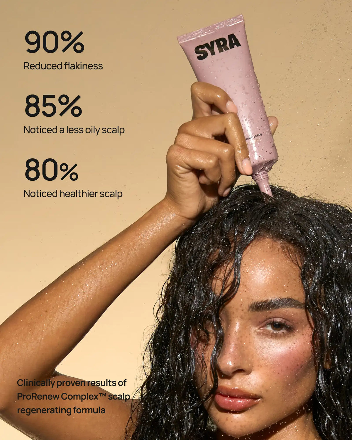 A woman with wet dark hair applies a pink-purple shampoo or treatment tube from SYRA to her scalp. The image includes marketing text on the left: '90% Reduced flakiness', '85% Noticed a less oily scalp', and '80% Noticed healthier scalp', with a beige background.