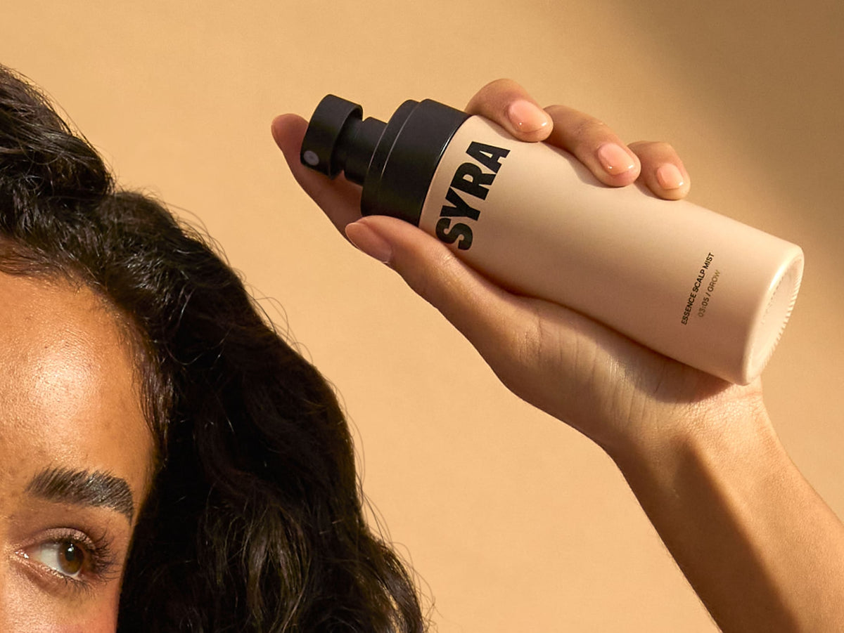 Model holding the syra essence scalp mist