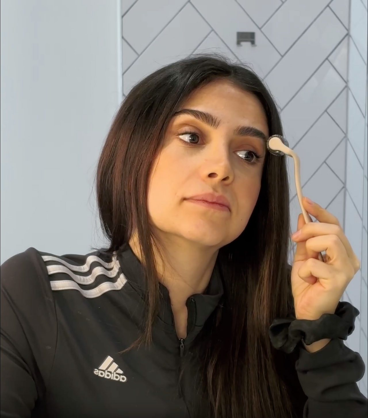 Video of a model applying the brow oil in her bathroom